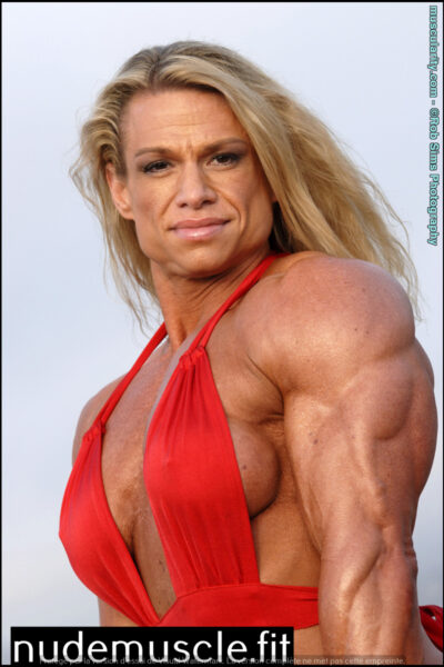 Female bodybuilder Tina Chandler shows off a red swimsuit on a beach. Image #12
